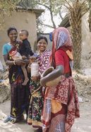 Eine Frau geht durch ein Dorf, um Reis in Rokkhagola zu abzugeben. Jede Familie bringt jede Woche ein Kilo Reis, um ihn in das Rokkhagola-System einzuzahlen.Projektpartner:  CCBVO - Centre for Capacity Building of Voluntary Organization